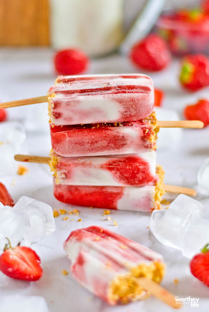 stacked Strawberry + Coconut Milk Crumble Popsicles on white background